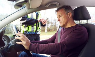 An employee is stopped by the police for committing a traffic offence