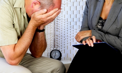 Woman telling a man about bereavement with the man greiving