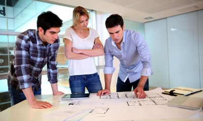 Group of architects looking at prints of a building plan