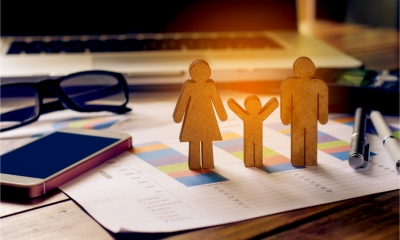 Cut-outs of a family standing on a financial report