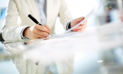 Business contracts Close up of a man holding a pen and signing a contract