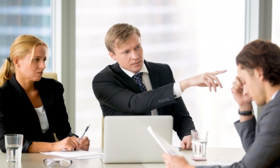Business manger pointing to a door to dismiss an employee