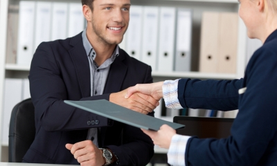 Contracts, disputes A business man and woman shake hands while handing over a contract