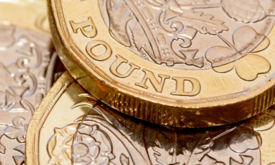 Multiple pound coins piled on top of one another