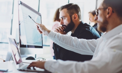 Debt recovery Men looking serious, pointing at figures on computer screen