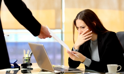 Thea head of HR handing an employee a discipline notice whilst at work