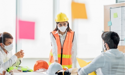 A group of colleagues taking off their ppe kit at a construction site