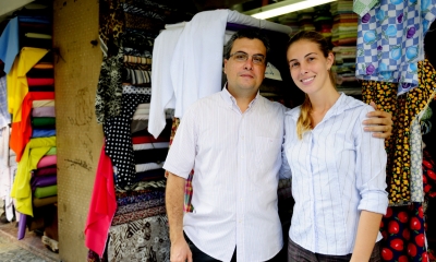 Man and a woman linking arms in front of a family textile business