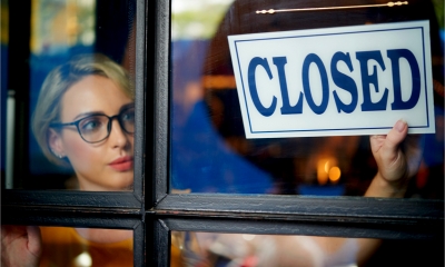 A female business owner closes her shop sign