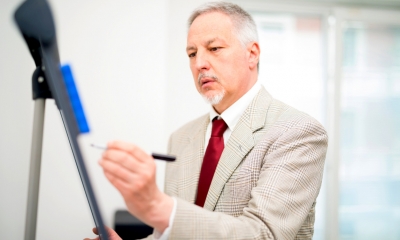 Finance and business strategy Businessman writing up plans on a flipboard