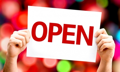 Forming a business - checklist Person holding up paper with words 'OPEN'
