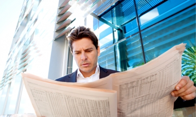 A man in a suit holding a newspaper