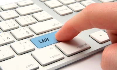 IT law Close up of computer keyboard with finger pressing key labelled 'law'