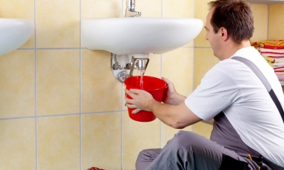 Loos, noise, heat, light... Six things you need to know about workplace rules A plumber holding a bucket below a broken sink in a workplace
