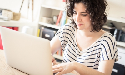 Managing home workers, remote workers, lone workers Young woman sits at home working on her laptop