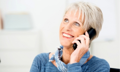 Senior woman chatting on her mobile phone smiling with delight as she listens to the conversation Senior woman chatting on her mobile phone smiling with delight as she listens to the conversation