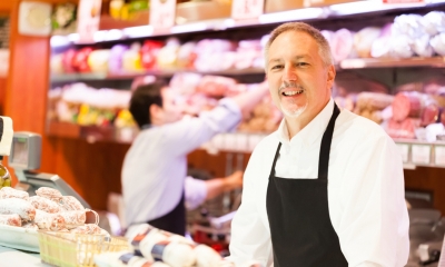 Business ownership and management Male business owner stands at his shop counter