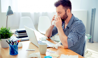 A man displays presenteeism by working whilst unwell