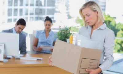 A woman clears her desk after being laid off
