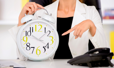 Female employee pointing at the clock