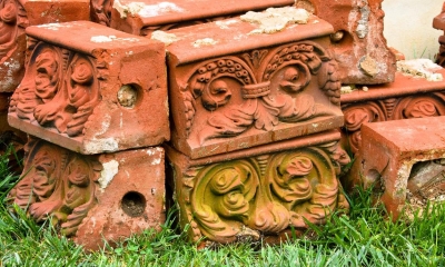 Multiple brown bricks with patterns on them with grass underneath