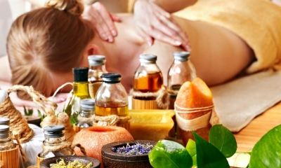 Woman receiving back massage with massage products in front of her