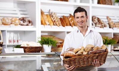 Man holding basket of baked goods in bakery