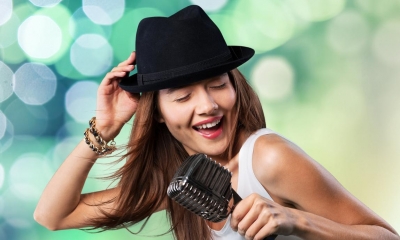 Woman in top hat singing into microphone