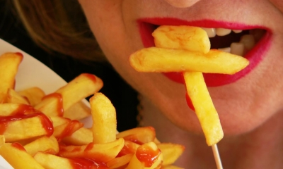 Woman eating chips with ketchup on them