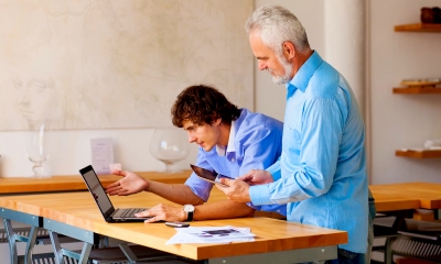 Forming a business Two business people in blue shirts working together at a table