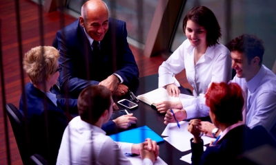 Company directors around board table looking relaxed