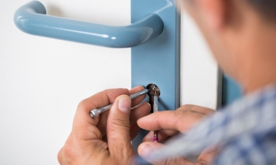 Man picking lock on white and blue door