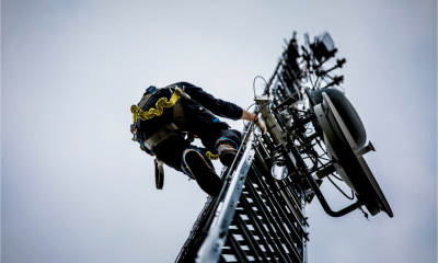A telecoms engineer climbs a mast