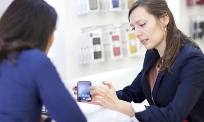 Woman in blue suit selling customer phone in phone shop