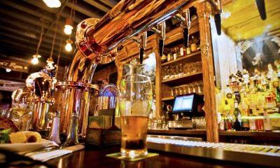 Pint of beer on bar side underneath taps