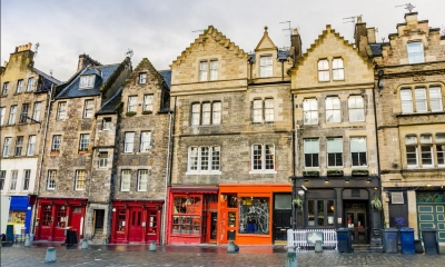 Multiple shops along high street with clouds in background