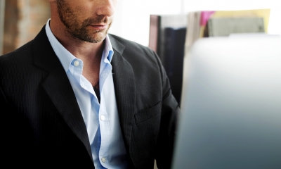 Cut-off picture of business man looking at laptop