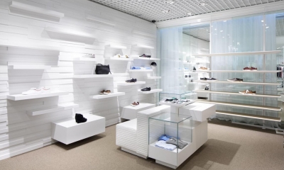 Shoes and a handbag on rails in a white retail shop