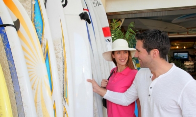 Man showing customer multiple different surfboards in surf shop