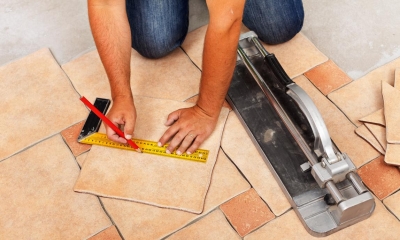 Man measuring and drawing on a tile to cut to shape