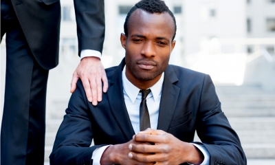 A man is consoling a colleague who has been dismissed