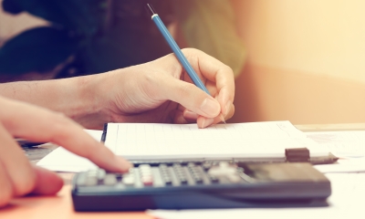 Using a notepad and calculator to work out a value