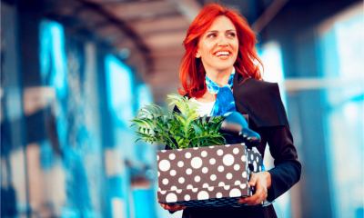 Happy businesswoman with a box full of belongings after giving up job.