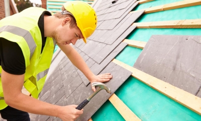 A roofer works on a roof