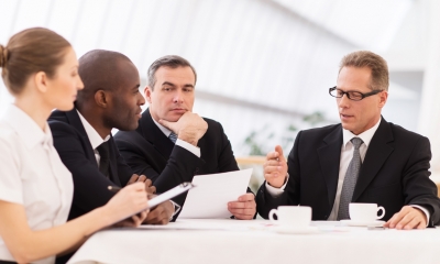 Shareholder and boardroom disputes Business people sitting at a table holding a discussion
