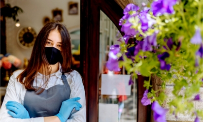 A local shopkeeper welcomes customers to her COVID secure shop
