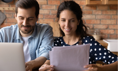 Man on laptop next to woman with paperwork