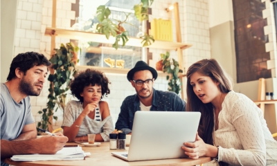 Group of people gathered around a laptop screen