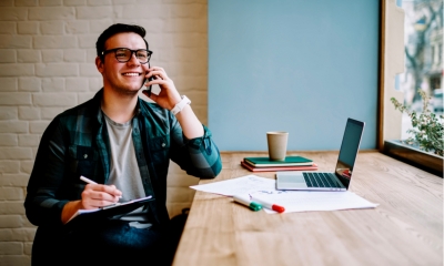 Cheerful male freelancer making telephone call Cheerful male freelancer making telephone call