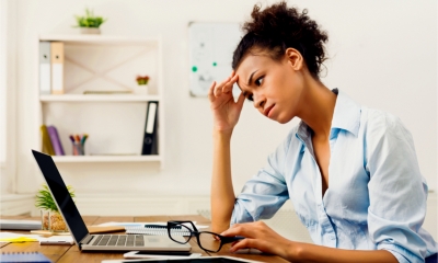 A female freelancer nurses a headache as she works